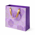 Sac cadeau 26 x 12 x 23 cm en papier violet et doré à motif floral avec anses ruban